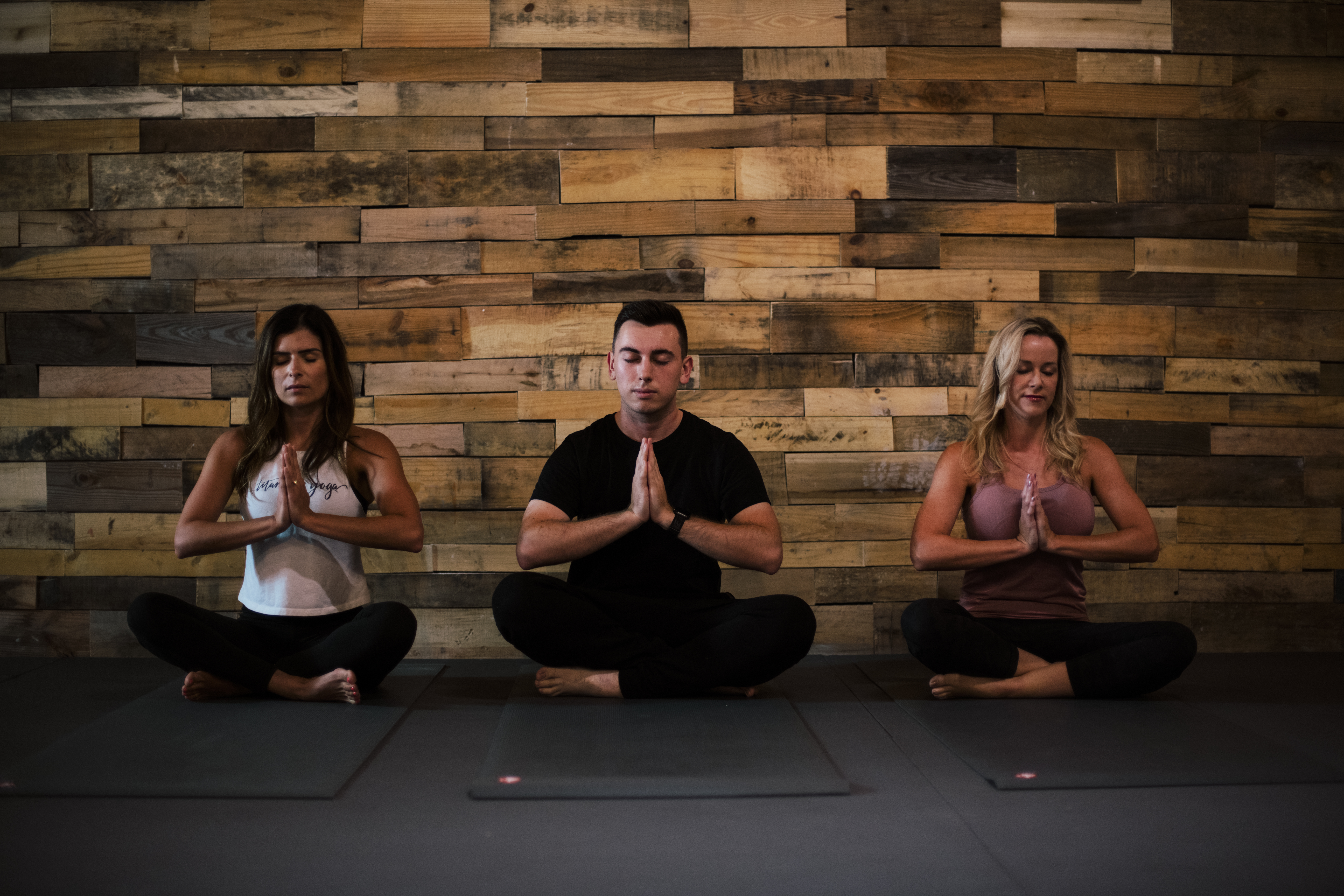 Several people in a meditation pose at Titanium Yoga